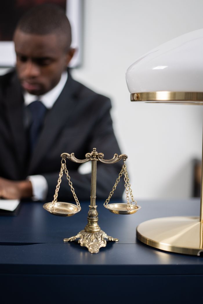 Mastering the First Impression: Your intriguing post title goes here A professional lawyer working at his desk with scales of justice symbolizing fairness and law competence.