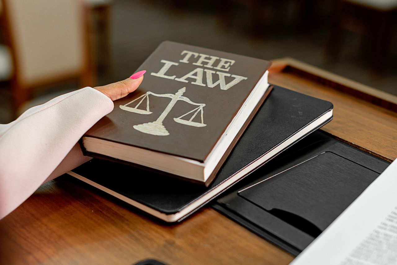 The Art of Drawing Readers In: Your attractive post title goes here Closeup image of a law book titled 'The Law' on a wooden desk with scales of justice.